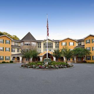 A large residential building with symmetrical architecture and a landscaped entrance area.