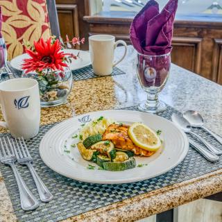 A beautifully set dining table with a plated meal and elegant decor.