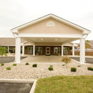 Front view of a building entrance with columns and landscaping.