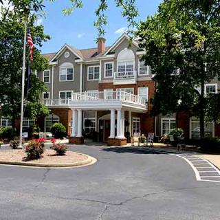 A residential building with a landscaped entrance on a sunny day.