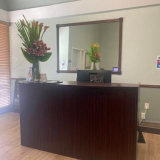 A welcoming reception area featuring a floral arrangement and a large mirror.
