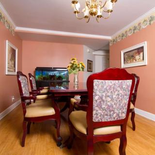 A well-decorated dining room with a wooden table, upholstered chairs, and a chandelier.