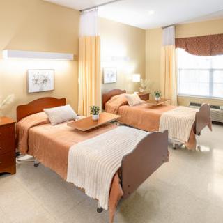 A well-organized hospital room featuring two twin beds, designed for patient comfort and care.