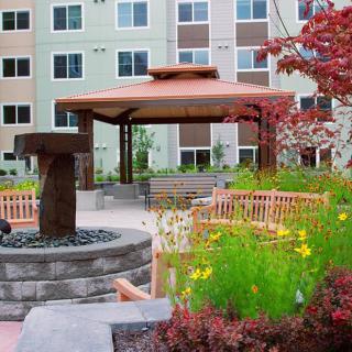 A beautiful garden with a gazebo and fountain in an apartment complex.