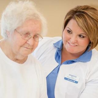 A caregiver supports an elderly woman, providing compassionate care.