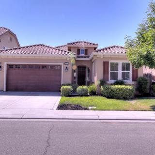 A suburban single-story house with a garage and landscaped front yard.