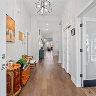 A modern, well-lit hallway with wood flooring and tasteful decor.