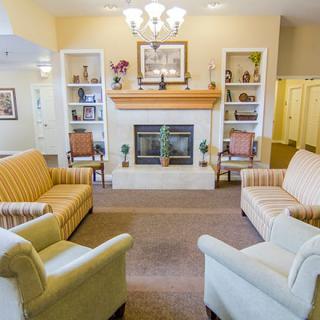 A cozy living room with sofas arranged around a fireplace, flanked by built-in shelves.