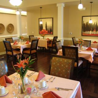 A cozy and elegantly arranged dining area with neatly set tables and warm decor.
