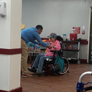A caregiver assists an elderly woman in a wheelchair, highlighting the importance of support and companionship.