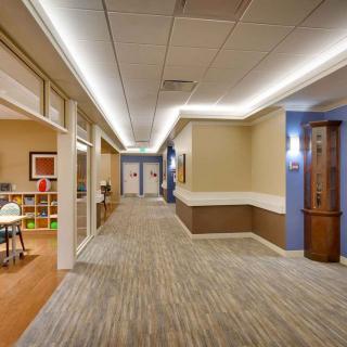A modern office hallway with sleek lighting and a carpeted floor.