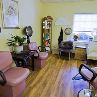 A cozy hair salon waiting area with chairs and salon equipment.