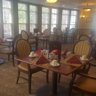 An empty dining room with neatly set tables and chairs.