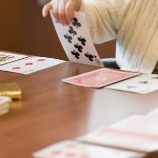 A person playing a card game at a table indoors.