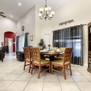 A spacious dining room with wooden furniture and a chandelier.