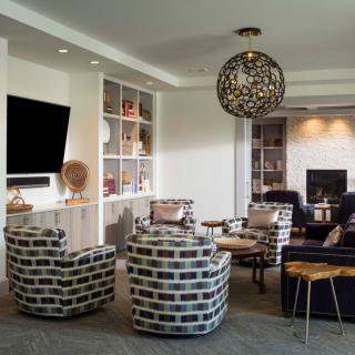 A modern living room with stylish furnishings and a prominent chandelier.
