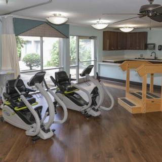 A neatly arranged indoor rehabilitation gym with exercise equipment.