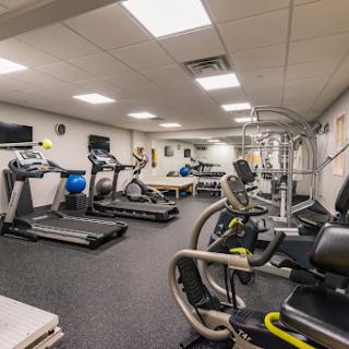 A well-equipped gym space featuring various exercise machines and a dedicated workout area.