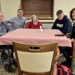 A joyful family gathering around the table, sharing moments together.