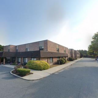 A commercial building with parking spaces, seen during the daytime.