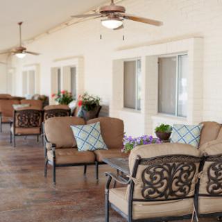 A cozy outdoor patio area featuring comfortable seating and decorative plants.