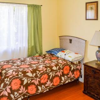 A cozy bedroom with floral bedding and a bedside lamp.