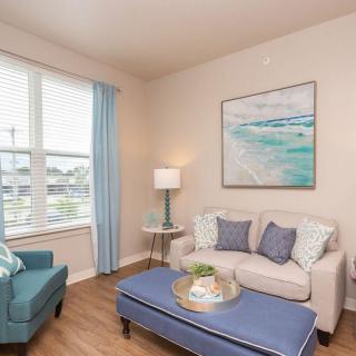 A cozy living room with a sofa, armchair, and coffee table, decorated with calming blue accents.