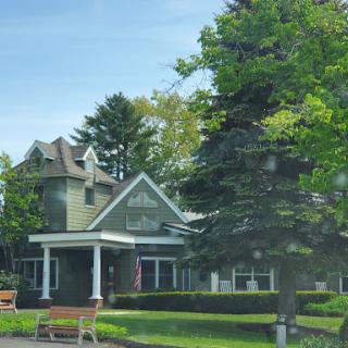 A picturesque house surrounded by lush greenery and a welcoming front porch.