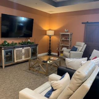A cozy living room setup featuring comfortable seating and a mounted TV.