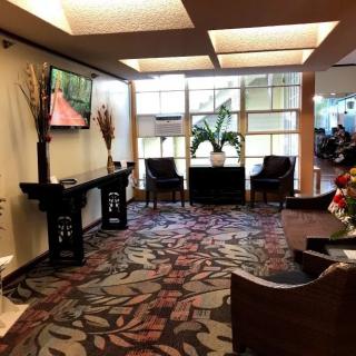 A well-decorated waiting room with comfortable seating and a television.