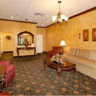 A warmly decorated living room featuring a beige sofa, wooden coffee table, and elegant chandelier.