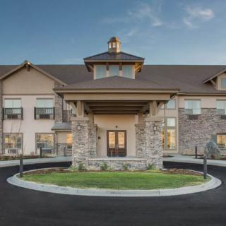 A modern hotel building with a stone facade and welcoming entrance.