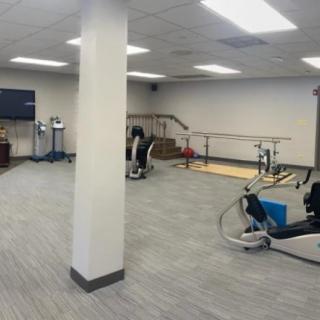 A spacious indoor gym equipped with various exercise machines and tools.