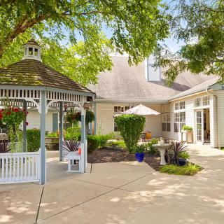 Charming outdoor garden with a gazebo and patio area.