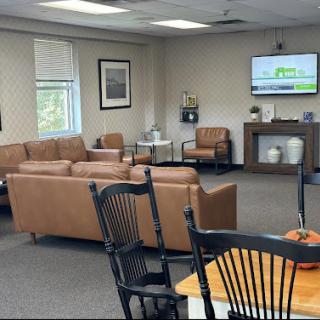 A cozy waiting room featuring comfortable seating and a television.