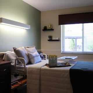 A well-lit hospital room featuring a comfortable patient bed and a cozy atmosphere.