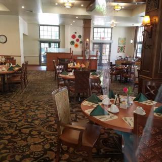 An indoor dining area with set tables and chairs, featuring decorative elements.