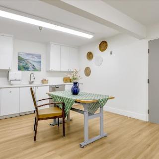 A bright and modern kitchen dining area featuring a simplistic table setup and elegant decor.