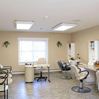 A bright beauty salon interior with chairs and mirrors arranged neatly.