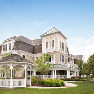 A Victorian-style building with a gazebo in a landscaped garden.