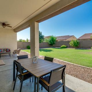 A cozy patio with a dining set, overlooking a spacious backyard lawn.