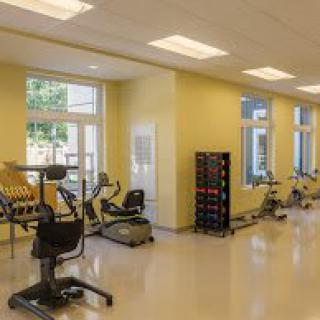 A well-lit gym with exercise bikes and fitness equipment.