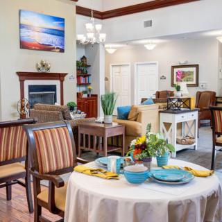 A cozy and inviting living room with a dining table set for two, featuring elegant decor and comfortable furniture.