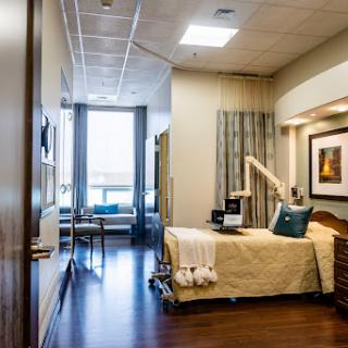 A well-lit and comfortable hospital patient room featuring modern furnishings.