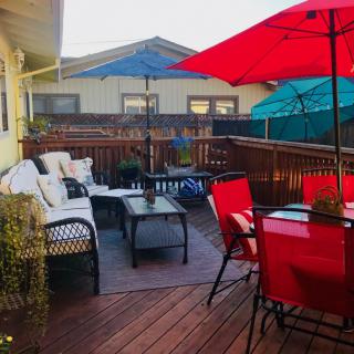 A cozy outdoor patio with colorful umbrellas and comfortable seating.