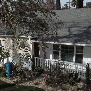 A cozy house with a small front yard and trees.