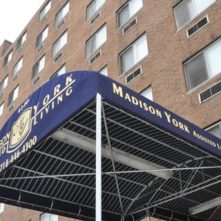 An awning with signage in front of an apartment building.
