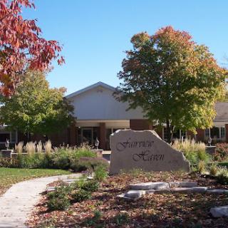 A welcoming view of a building surrounded by vibrant autumn foliage and a well-maintained garden pathway.