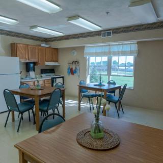 A well-lit kitchen and dining area with wooden furniture and modern appliances.