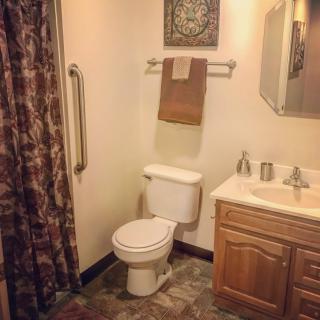 A clean and simple bathroom with a toilet, sink, and shower area.